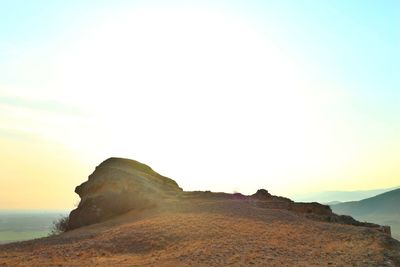 Rock formations in sea against sky during sunset