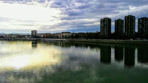 Reflection of city in water against sky