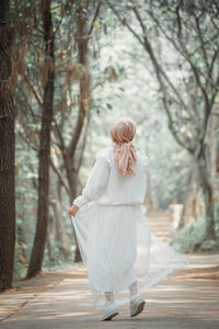 Rear view of woman walking on footpath