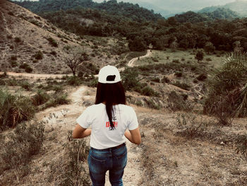Rear view of woman standing on landscape
