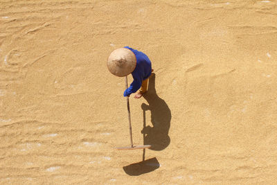 High angle view of farmer with work tool on grains