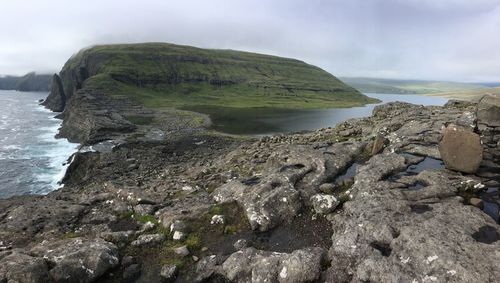 Scenic view of rocks on shore against sky