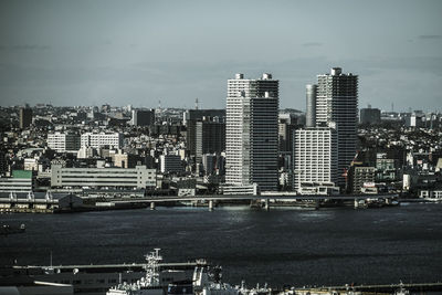 Modern buildings by sea against sky in city