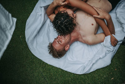 High angle view of friends resting on bed