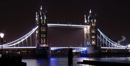 Suspension bridge over river at night