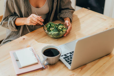 Midsection of woman holding food on table