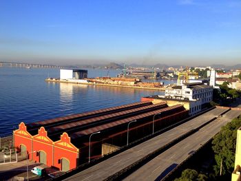 High angle view of buildings by river against blue sky