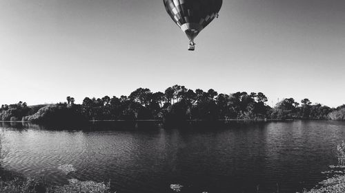 Parachute flying over calm lake in forest