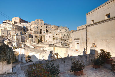 Buildings in town against clear blue sky