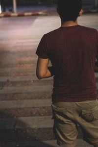 Rear view of boy standing on street