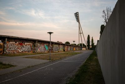 Graffiti on wall by street against sky