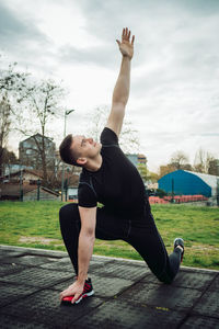 Full length of woman with arms raised against sky