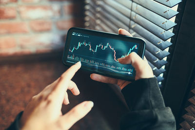 Person investing trading on stock cryptocurrency market using investing application on smartphone