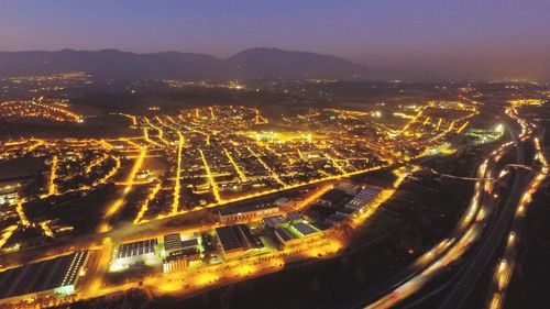 High angle view of illuminated cityscape against sky at night