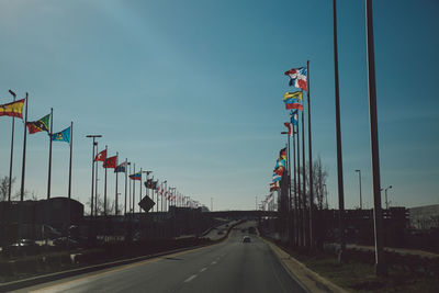 Road amidst various flags against sky