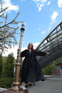 Portrait of smiling young woman against sky