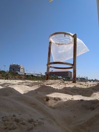 Low angle view of built structure on sand against clear sky