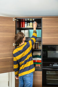 Rear view of boy standing in factory