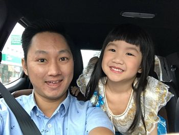 Portrait of happy smiling boy in car