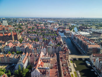 High angle view of the illuminated city by the river against the sky