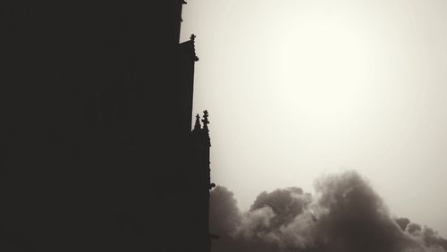 Low angle view of silhouette cross against clear sky