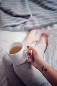 Woman drinking coffee cup on bed