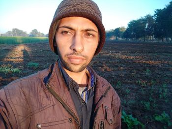 Portrait of young man standing against plants