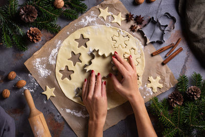 Christmas baking at home. female hands making snowflake cookies from fresh dough on a kitchen table.