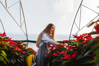 Woman standing by flowering plants