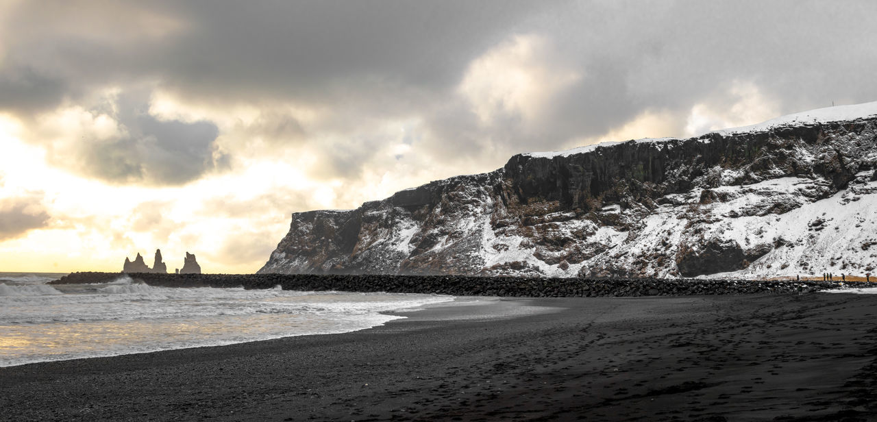 sky, water, cloud, sea, land, wave, beach, scenics - nature, beauty in nature, coast, ocean, environment, nature, shore, landscape, cold temperature, travel destinations, snow, mountain, travel, rock, winter, horizon, wind wave, sand, outdoors, morning, tranquility, body of water, dramatic sky, coastline, no people, tranquil scene, holiday, tourism, sports, terrain, motion, non-urban scene, sunlight, vacation, ice, trip