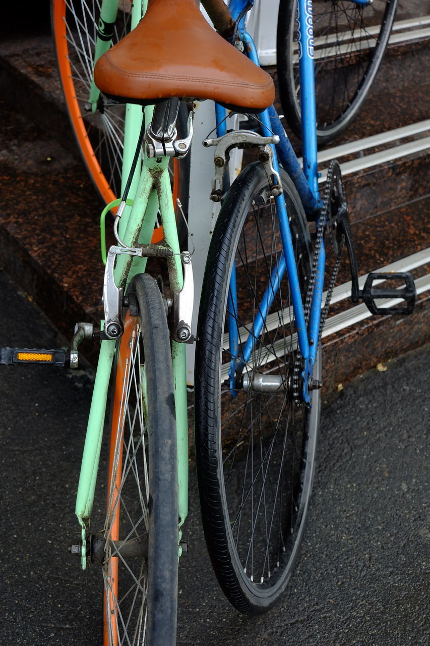 HIGH ANGLE VIEW OF BICYCLE PARKED BY METAL