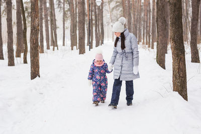 Full length of woman on snow covered trees during winter