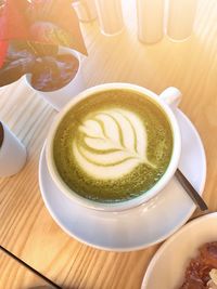 High angle view of cappuccino and coffee on table