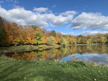 Scenic view of lake by trees against sky