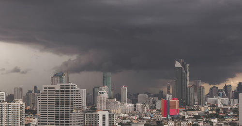 Modern buildings in city against storm clouds