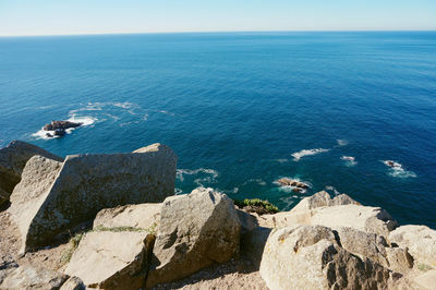 High angle view of rocks by sea against sky