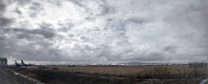 Scenic view of beach against cloudy sky