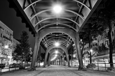 Illuminated street lights in city against sky at night