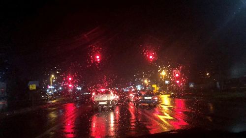 Cars on illuminated road during rainy season at night