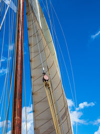 Low angle view of sailboat against blue sky