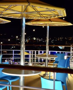 Empty chairs and table in restaurant at night