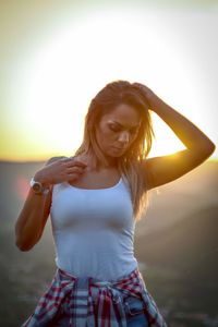 Beautiful woman standing against sky during sunset