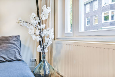 Low section of woman sitting on sofa at home