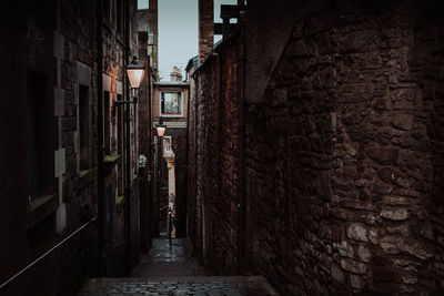 Walkway amidst buildings against sky