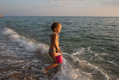 Rear view of woman standing at beach