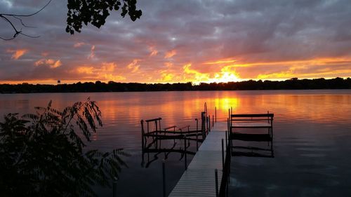 Pier on lake at sunset