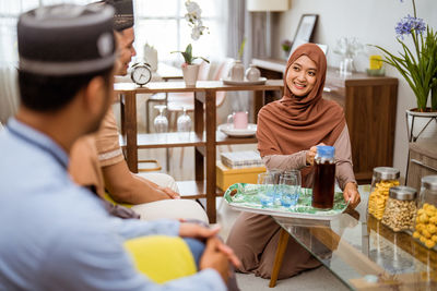 Smiling woman serving drink to guest