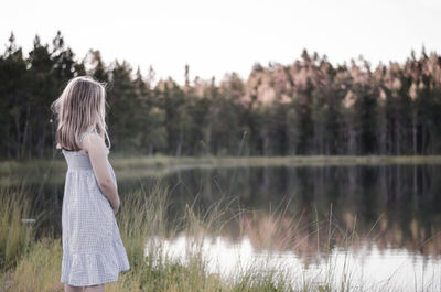 Girl standing by lake