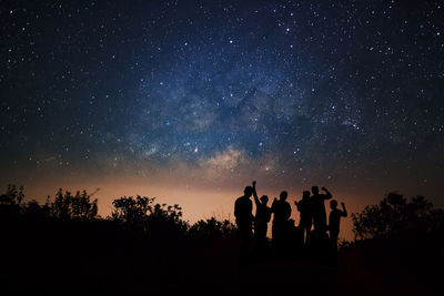 Silhouette people against sky at night