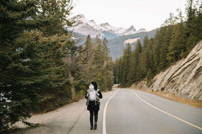 Rear view of woman on road against mountain range